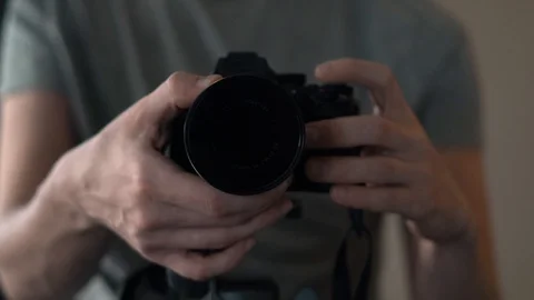 A man with a camera adjusts the focus of the camera on a close-up lens 스톡 동영상 88970887