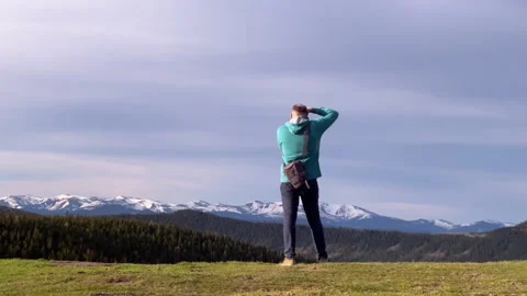 Man with camera bag trekking in mountains, scouting location for landscape Stock Footage 346550832