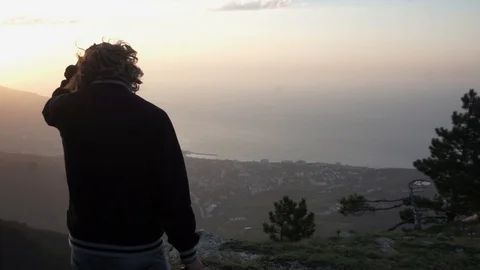 Man with a camera down to the mountain ledge 스톡 동영상 102697041