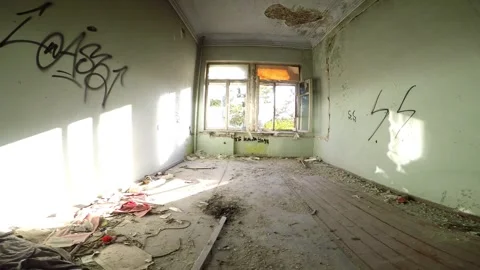 A man with a camera enters an empty room of an old abandoned house and goes to Stock Footage 160911591