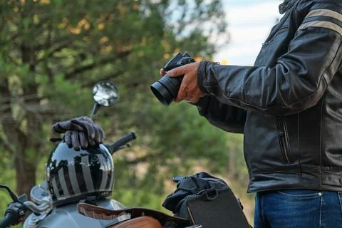Man with a camera in his hand next to his bike. Stock Photos