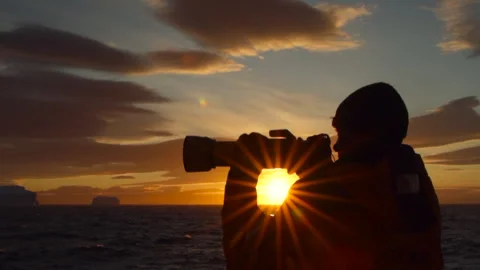 A Man with a Camera looking out to Sea then Moves in Slo Mo to Reveal a Stock Footage 346176165