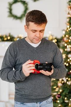 Man with camera in red case against of Christmas decorations. photo school Stock Photos