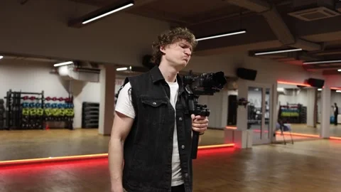 Man with camera shows frustration in gym studio 스톡 동영상 332116850