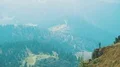 The man with a camera stands on the edge of a cliff in mountains 4k or 4k+ Resolution