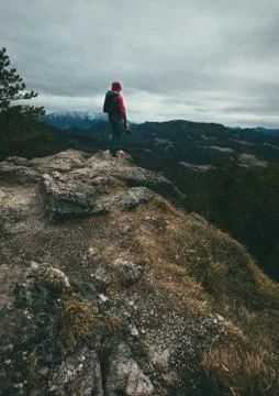 Man with camera stands on mountain top on a cloudy moody day Stock Photos