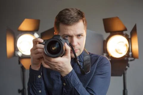 Man with a camera in the studio on the background lighting Stockfoto's