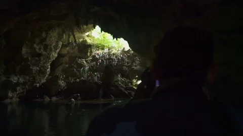 A man with a camera takes a people go down into the cave Stock Footage 71287281