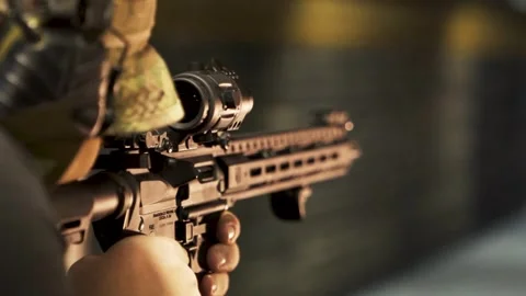 Man in a camouflage uniform fires a machine gun at a shooting range at a Stock Footage 254028457
