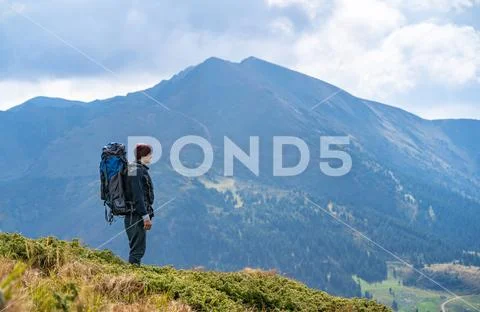 The man with a camping backpack standing on the mountain Stock Photos