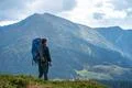 The man with a camping backpack standing on the mountain Photo