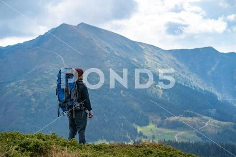 The man with a camping backpack standing on the mountain Stock Photos