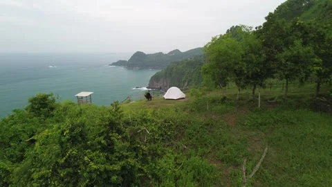 A man camping in the hills bordering the beach Video stock 284790322