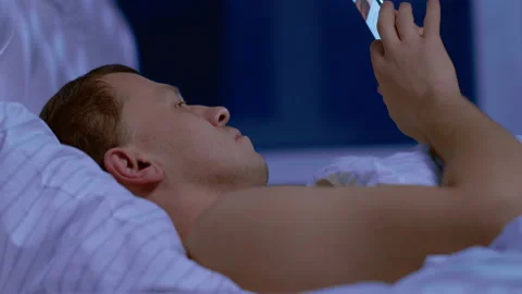 The man can not sleep, he is watching the news in his phone Stock Footage 131740563