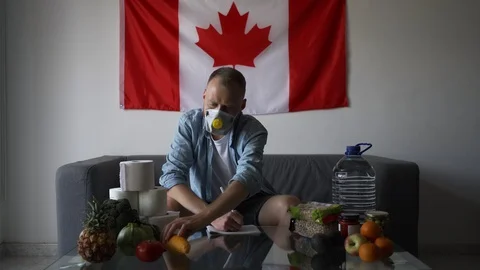 A man in Canada sits on self-isolation while staying at home. Covid-19 Video stock 127869740