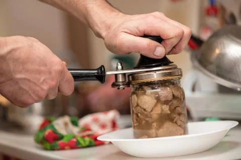Man is canning pork stew, process close-up. Homemade traditional cooking Fotos Stock