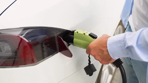 A man cannot insert a charging cable into an electric car Stock Footage 251765765