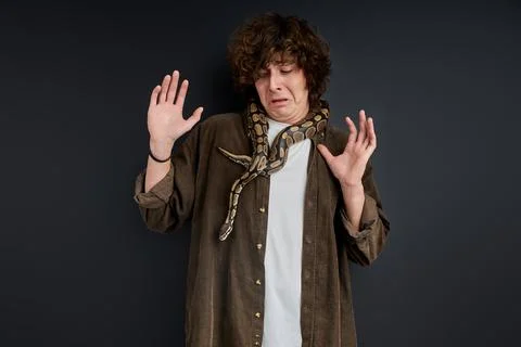 Man cannot move when a snake wraps around his neck and shoulders Stock Photos