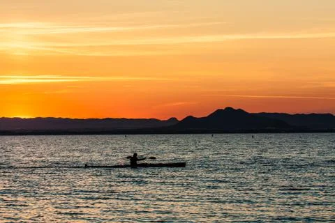 Man canoeing on sunset Stock Photos
