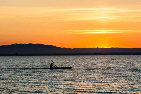 Man canoeing on sunset Stock Photos
