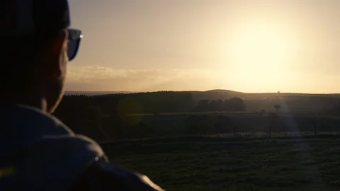 Man with cap looking out at misty sunrise. Stock Footage 87856889