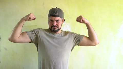 A man in a cap shows biceps on his hands 4K Stock-Footage 125283424