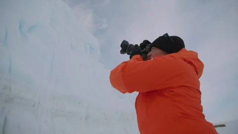 Man captures winter beauty while photographing snow-covered landscape in cold Stock Footage 288191631