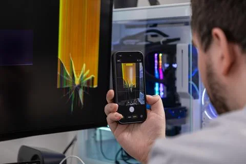 Man capturing a broken computer monitor's screen displaying visual artifact.. Foto stock