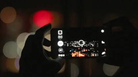 Man capturing video with his camera in the night, night lights bokeh Video stock 53519756