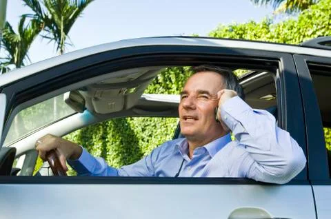 Man in a car and talking on a mobile phone Stock Photos