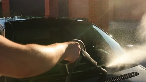 Man car, car wash using high pressure water jet. the sun shines Stock-Footage 113468620