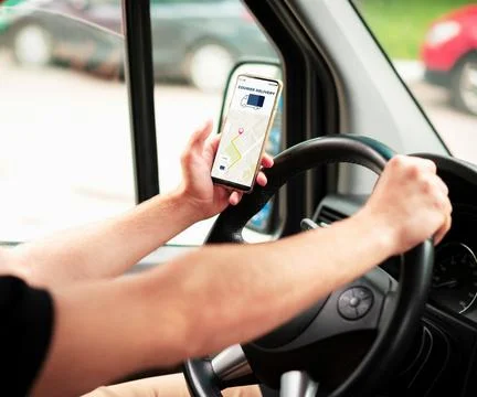 The man in the car is holding the Maps application Stock Photos