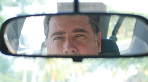 Man in car looking straight into rear view mirror  2 Stock Footage 32273448