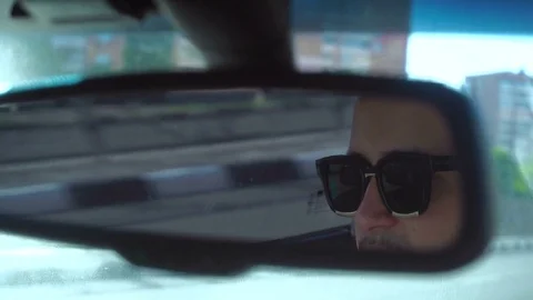 Man in the car rides view from rear-view mirrors Video stock 76449556