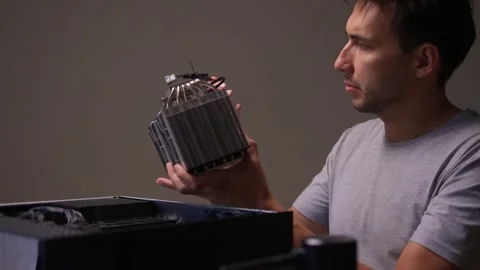 A man carefully assembling a CPU cooler in a precise tech setup, ensuring Stock Footage 312529656