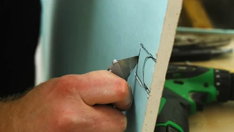 Man carefully cuts piece of plasterboard panel with small knife Stock Footage 304407672
