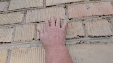 The man carefully feels the brick wall with his hand.From the first person. 動画素材 342421956
