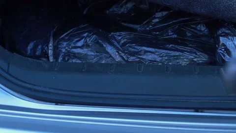 Man carefully hiding packages in bottom of trunk, smuggling, drug trafficking Stock Footage 99268416