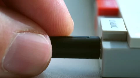 Man carefully inserts wire into output hole of digital device Stock Footage 279156929