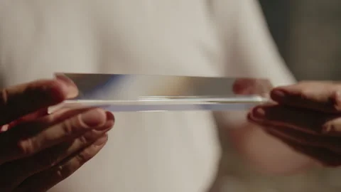 Man carefully spinning triangular glass prism, demonstrating phenomenon of light Stock Footage 312352528