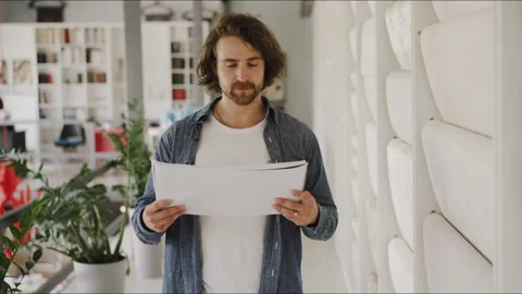 A man is carefully studying a construction project in a wallpaper studio Vídeo Stock 144536549