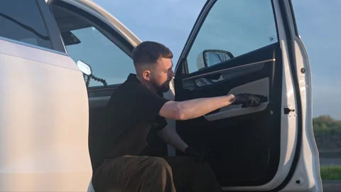 A man carefully wipes the exterior panel of a car door Stock Footage 335214426