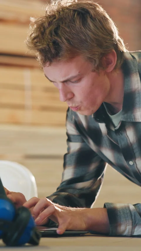 Man, carpenter and typing with laptop in warehouse for lumber project or Stock Footage 343911427