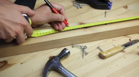 Man carpenter measuring a wood board and uses a marker pen Stock Footage 54123765