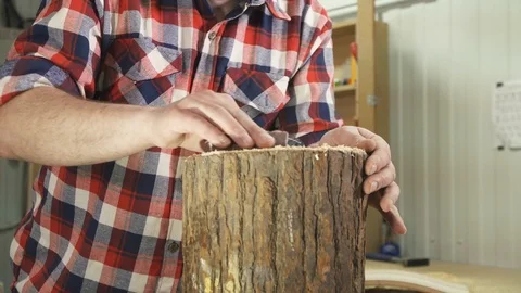 Man carpenter in a shirt with a beard blows shavings in the workshop Stock Footage 88885949