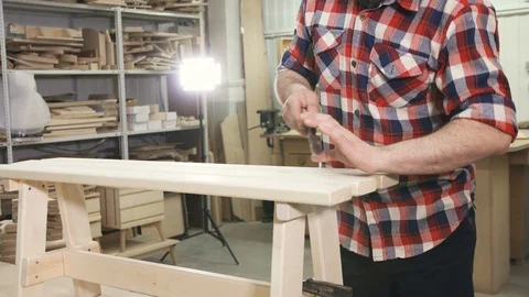 Man carpenter in a shirt with a beard in the workshop is working on a wooden Video stock 88961494