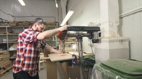 Man carpenter in a shirt using drilling machine in workshop Stock Footage 88963107