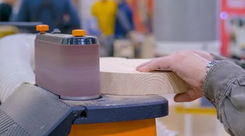 Man carpenter using belt sander machine, polishing wood product: close up Stock Photos