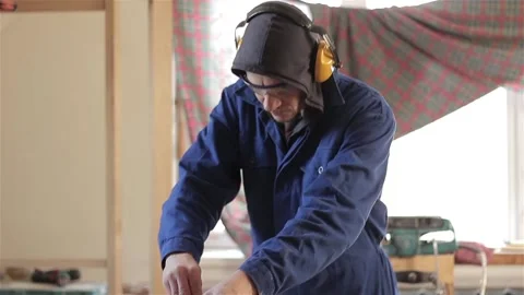 Man carpenter in workshop working with hardwood wearing blue uniform indoors  動画素材 88075270