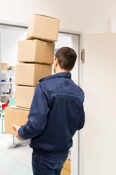 Man carries heavy boxes. Boxes do not fit on the height of the doors. Acciden Stock Photos